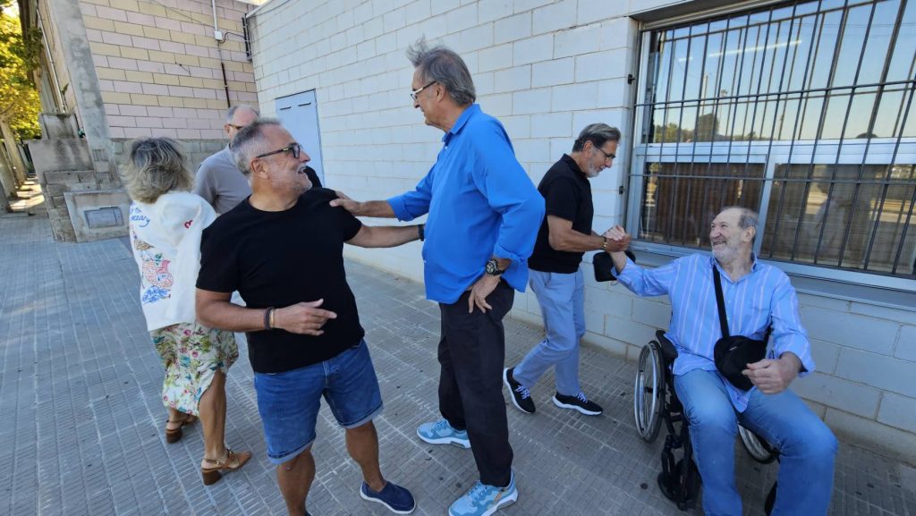 Luis Miguel Santillana saludando a un asistente al acto y Manolo Flores saludando a Miguel Angel Estrada